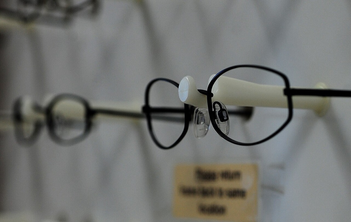Metal spectacle frames in different shapes hanging on a display rack at an optometry clinic